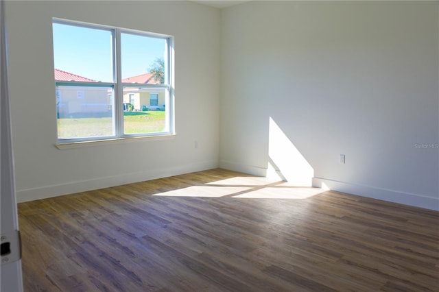 unfurnished room with dark hardwood / wood-style flooring