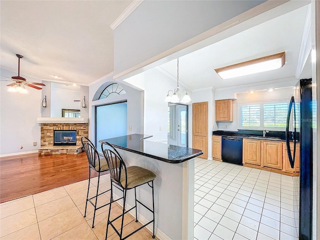 kitchen with ornamental molding, black dishwasher, and light hardwood / wood-style flooring