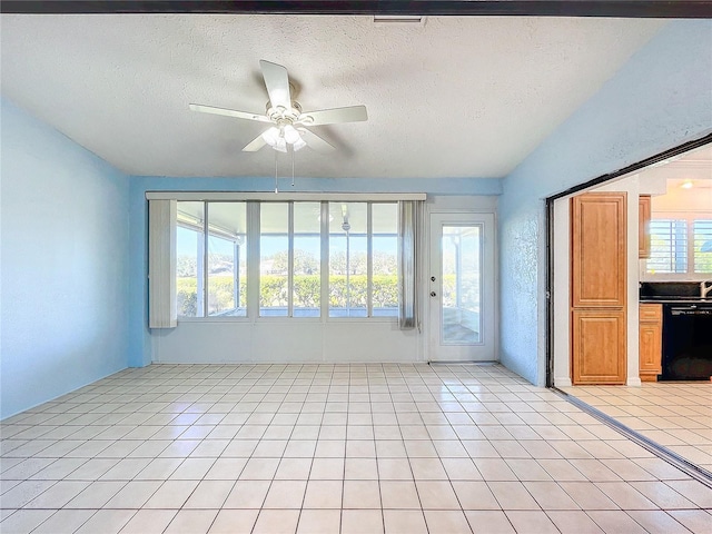 unfurnished living room featuring ceiling fan, light tile patterned floors, and a textured ceiling