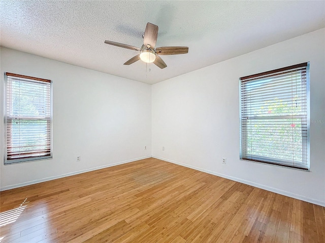 unfurnished room with ceiling fan, light hardwood / wood-style floors, and a textured ceiling