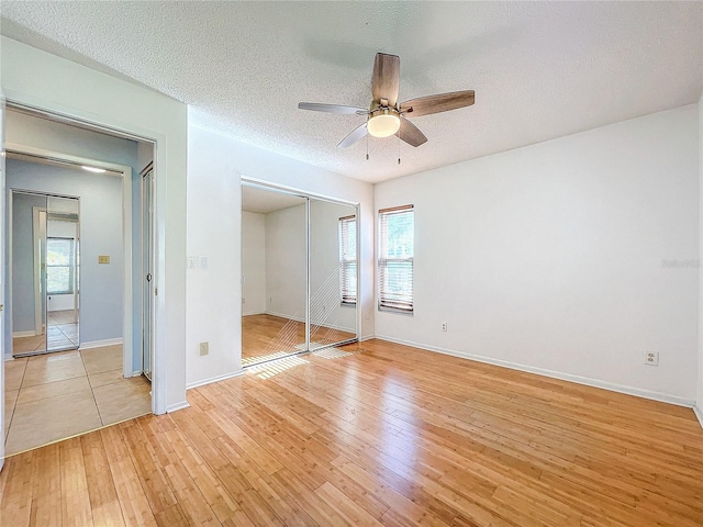 unfurnished bedroom with ceiling fan, multiple windows, and light hardwood / wood-style flooring