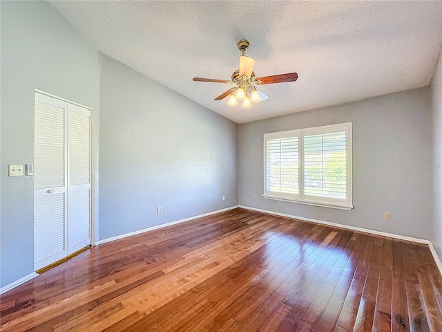 unfurnished bedroom with ceiling fan, a closet, wood-type flooring, and a textured ceiling