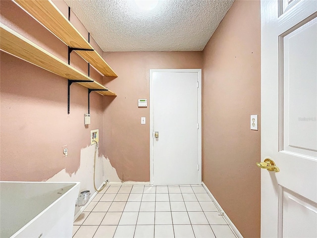 washroom featuring hookup for a washing machine, a textured ceiling, and light tile patterned flooring