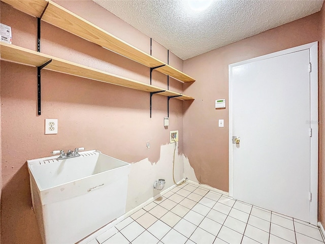 washroom featuring hookup for a washing machine, light tile patterned floors, and a textured ceiling