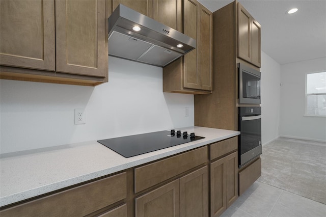 kitchen featuring light tile patterned floors, stainless steel appliances, and extractor fan