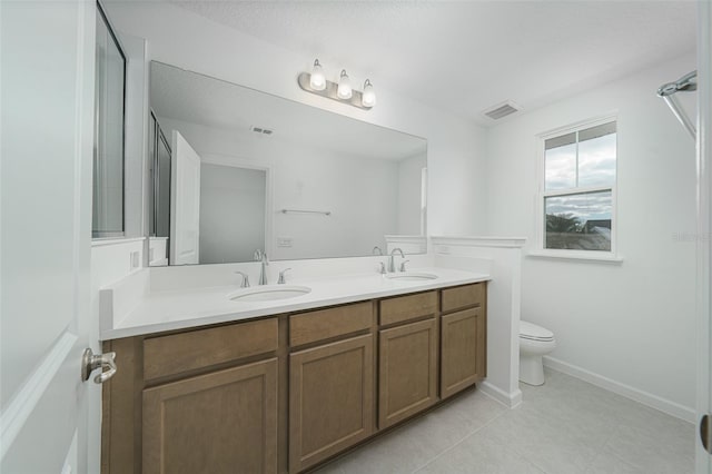 bathroom with tile patterned flooring, vanity, and toilet