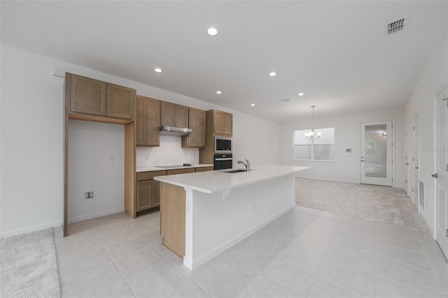 kitchen featuring sink, an inviting chandelier, pendant lighting, a center island with sink, and appliances with stainless steel finishes