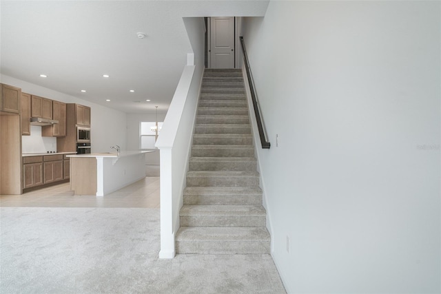 stairway featuring sink and carpet floors