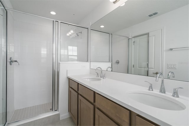 bathroom featuring tile patterned flooring, vanity, and walk in shower