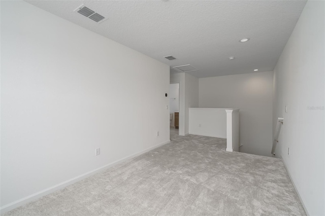 empty room featuring light carpet and a textured ceiling