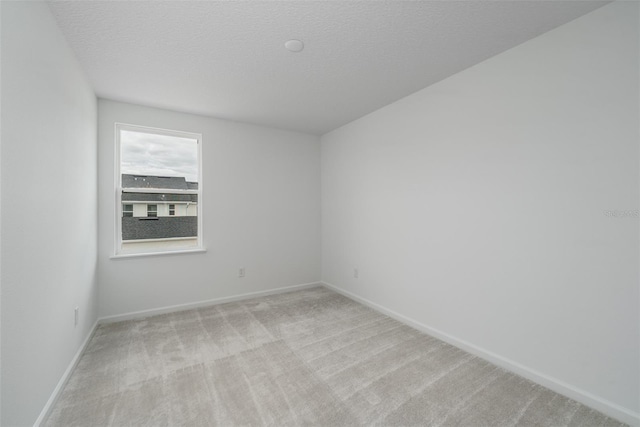 carpeted empty room featuring a textured ceiling