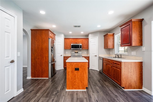 kitchen featuring a center island, stainless steel appliances, dark wood-type flooring, and sink