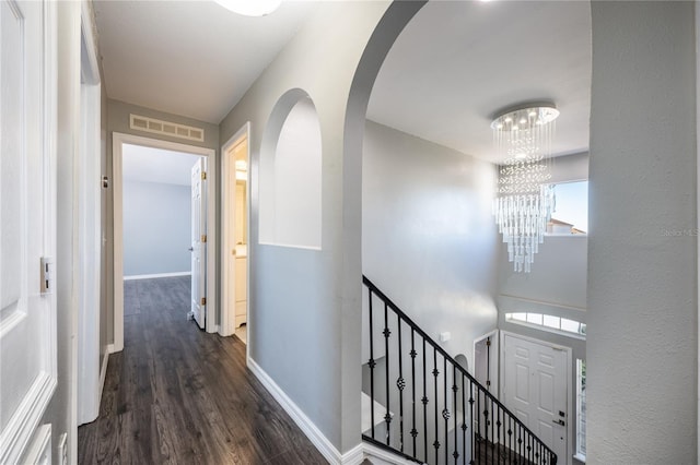 corridor featuring a notable chandelier and dark hardwood / wood-style flooring