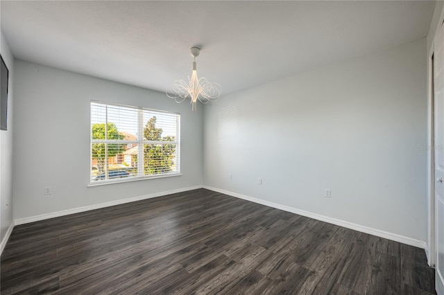 unfurnished room with dark hardwood / wood-style floors and a chandelier