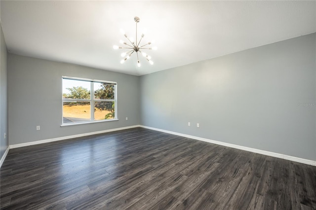 empty room featuring a chandelier and dark hardwood / wood-style floors