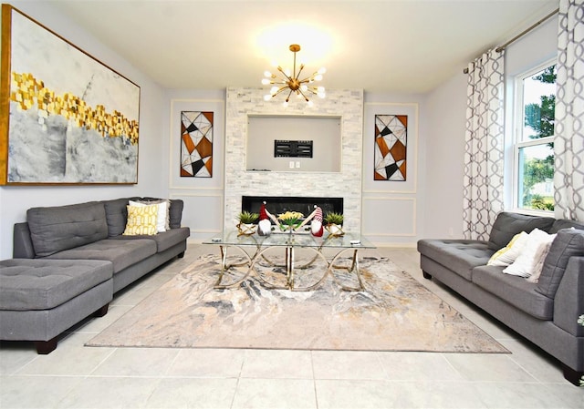 tiled living room featuring a fireplace, an inviting chandelier, and plenty of natural light