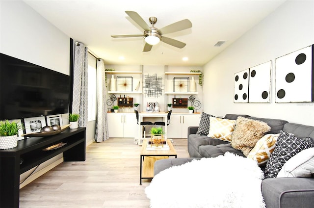 living room with ceiling fan and light wood-type flooring