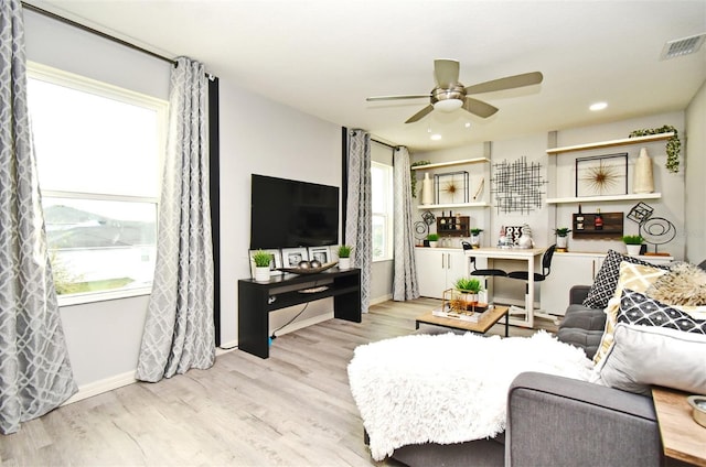 living room with ceiling fan and light hardwood / wood-style flooring