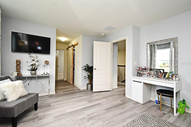 interior space featuring a barn door and light hardwood / wood-style floors