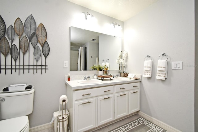 bathroom with tile patterned floors, vanity, toilet, and curtained shower