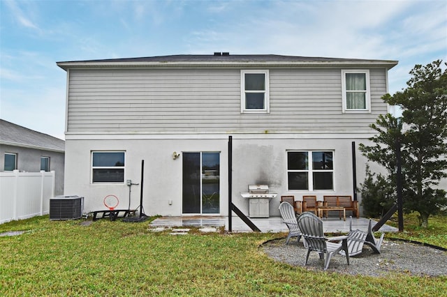 rear view of property featuring a lawn, central air condition unit, and a patio area