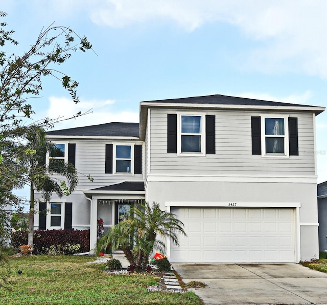 view of front facade with a garage and a front lawn