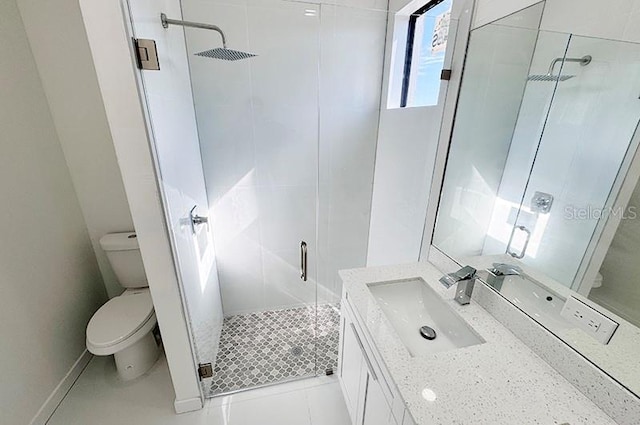 bathroom featuring tile patterned flooring, vanity, a shower with shower door, and toilet