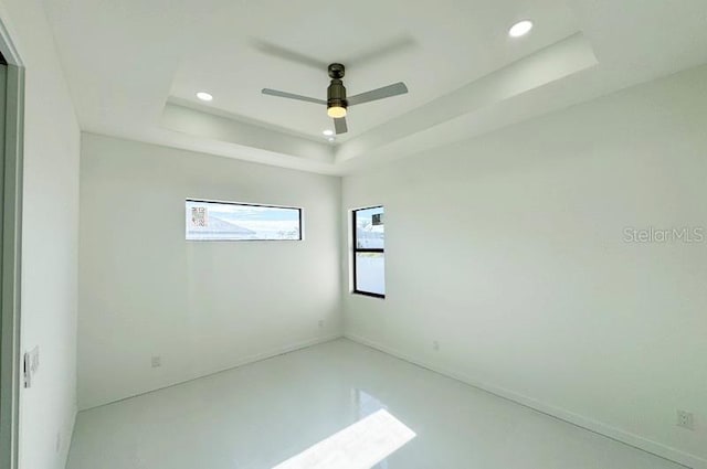 unfurnished room featuring ceiling fan and a tray ceiling