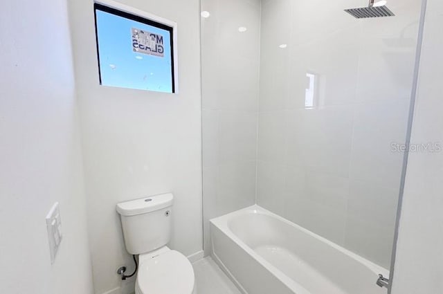 bathroom with tiled shower / bath combo and toilet