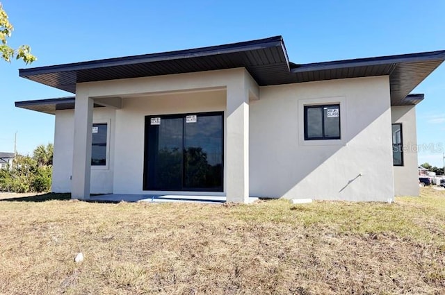 rear view of property featuring a lawn