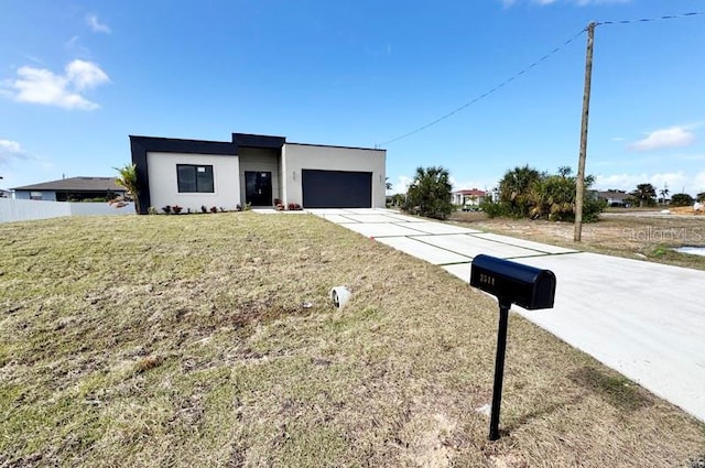 view of front of property featuring a garage and a front lawn