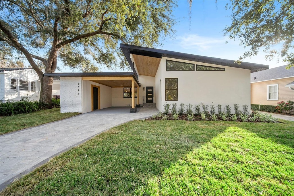 contemporary house with a front yard and a carport