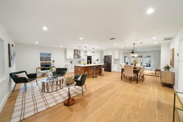 living room featuring ceiling fan and light hardwood / wood-style flooring