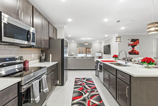 kitchen featuring dark brown cabinetry, sink, decorative light fixtures, light tile patterned floors, and appliances with stainless steel finishes