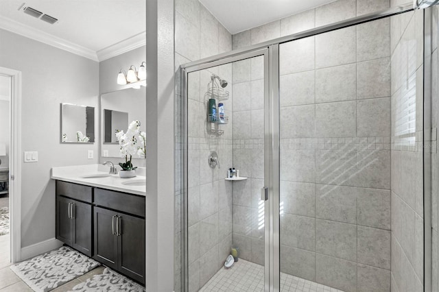 bathroom featuring tile patterned floors, vanity, a shower with shower door, and ornamental molding