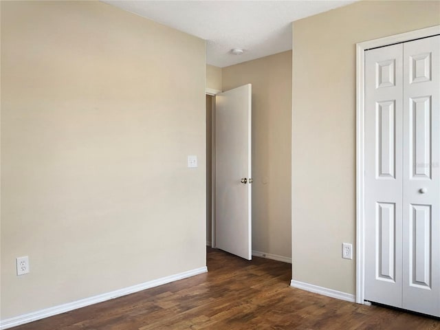 unfurnished bedroom featuring dark hardwood / wood-style floors, a textured ceiling, and a closet