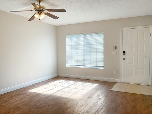 foyer with ceiling fan, light hardwood / wood-style flooring, and a textured ceiling