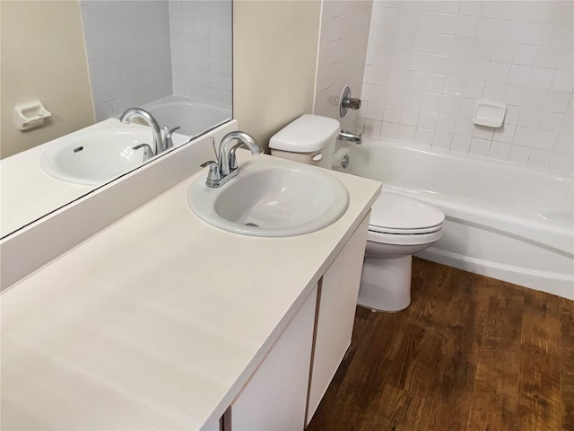 full bathroom with hardwood / wood-style floors, vanity, toilet, and tiled shower / bath