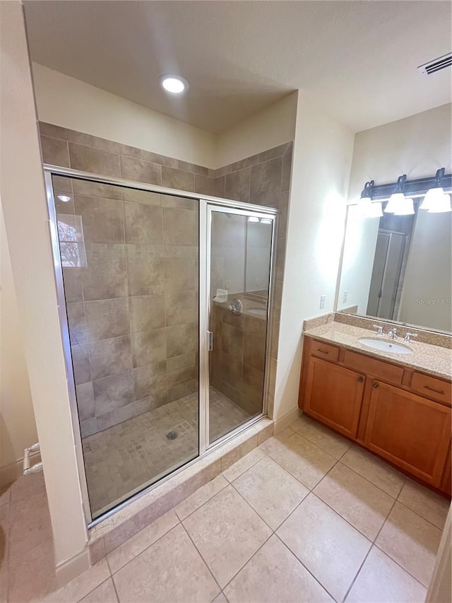 bathroom with tile patterned floors, vanity, and walk in shower