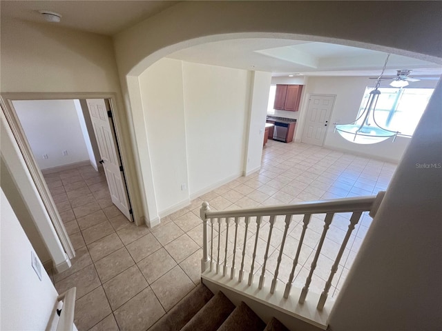 staircase featuring tile patterned floors and ceiling fan