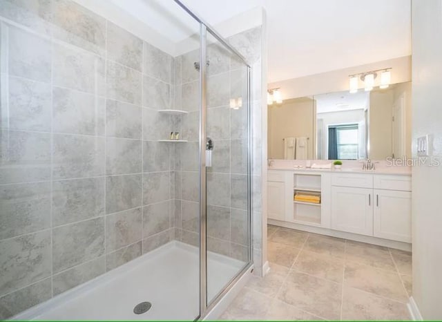 bathroom featuring tile patterned floors, vanity, and a shower with shower door