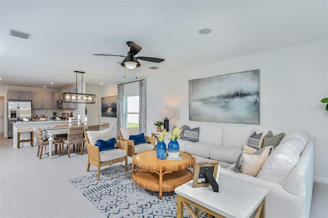 living room with ceiling fan, light tile patterned floors, and sink