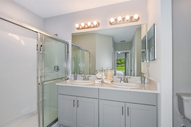 bathroom featuring vanity, toilet, and an enclosed shower