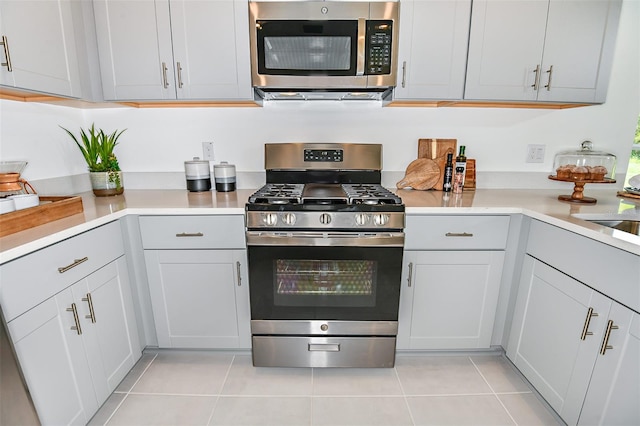 kitchen with light tile patterned floors and stainless steel appliances