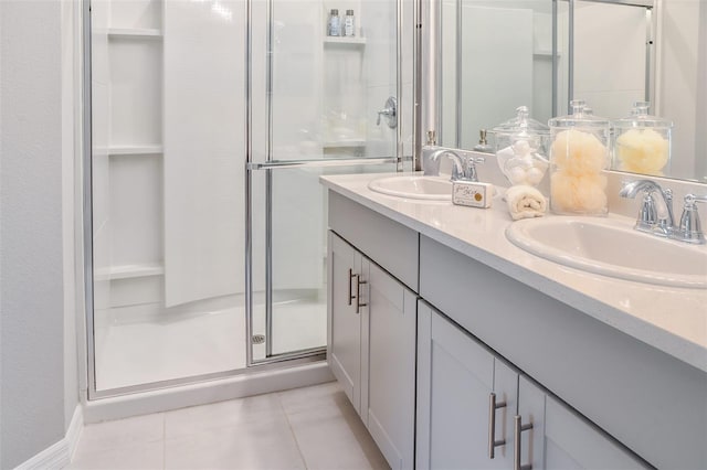 bathroom with a shower with door, vanity, and tile patterned flooring