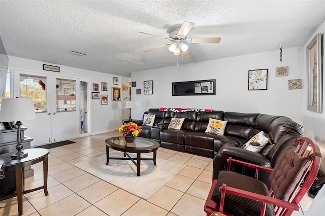 tiled living room featuring french doors, a textured ceiling, and ceiling fan