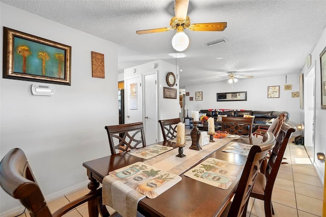 tiled dining room featuring a textured ceiling and ceiling fan