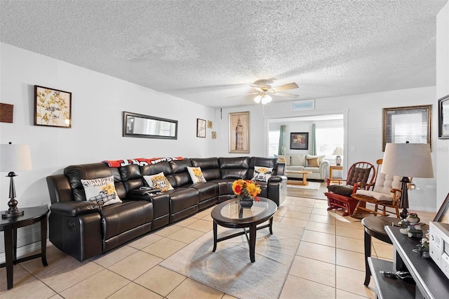 living room featuring ceiling fan, light tile patterned floors, and a textured ceiling