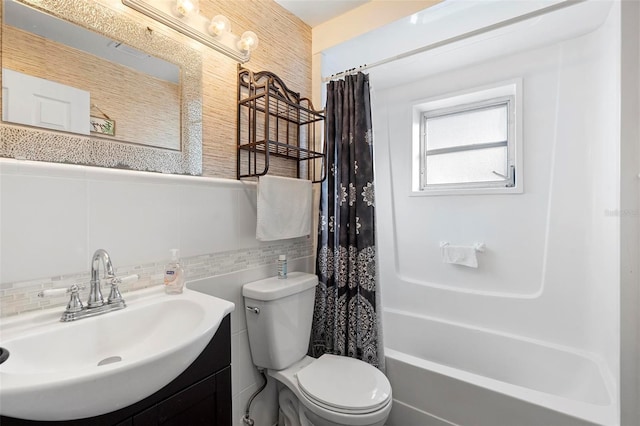 full bathroom with shower / bath combo, toilet, tile walls, and vanity