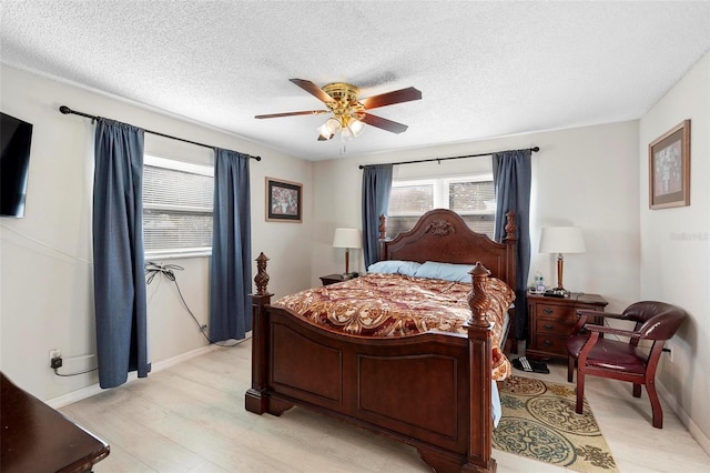 bedroom with ceiling fan, a textured ceiling, and light wood-type flooring